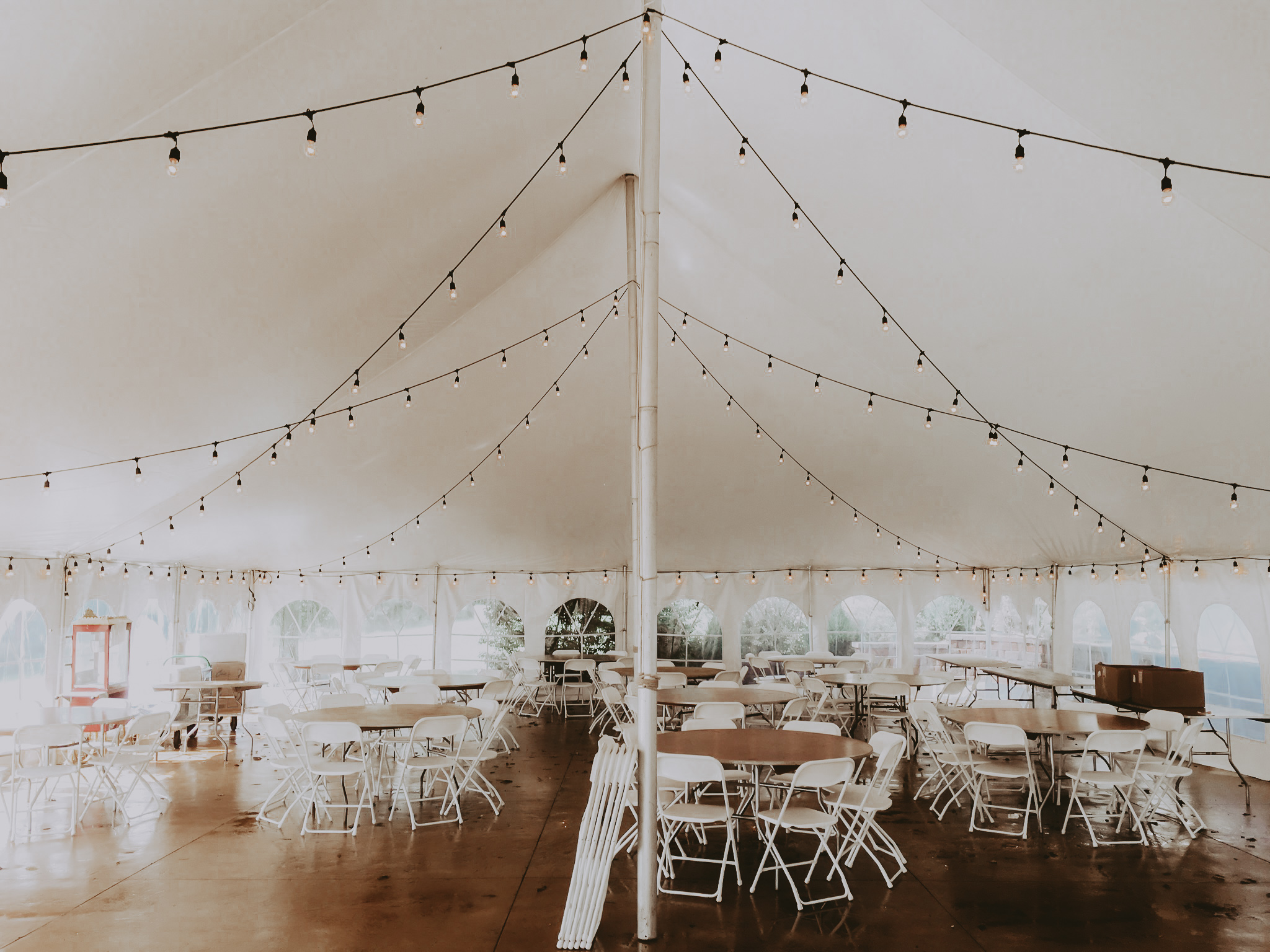 https://bigtentevents.com/wp-content/uploads/40-x-60-rope-and-pole-tent-with-cafe-lights-tables-chairs-and-popcorn-machine.jpg
